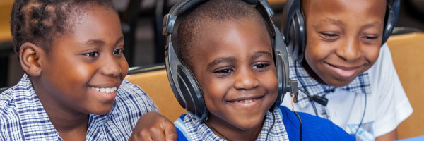 kids smiling while listening on headphones