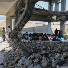 children in Yemen studying in a school destroyed by war