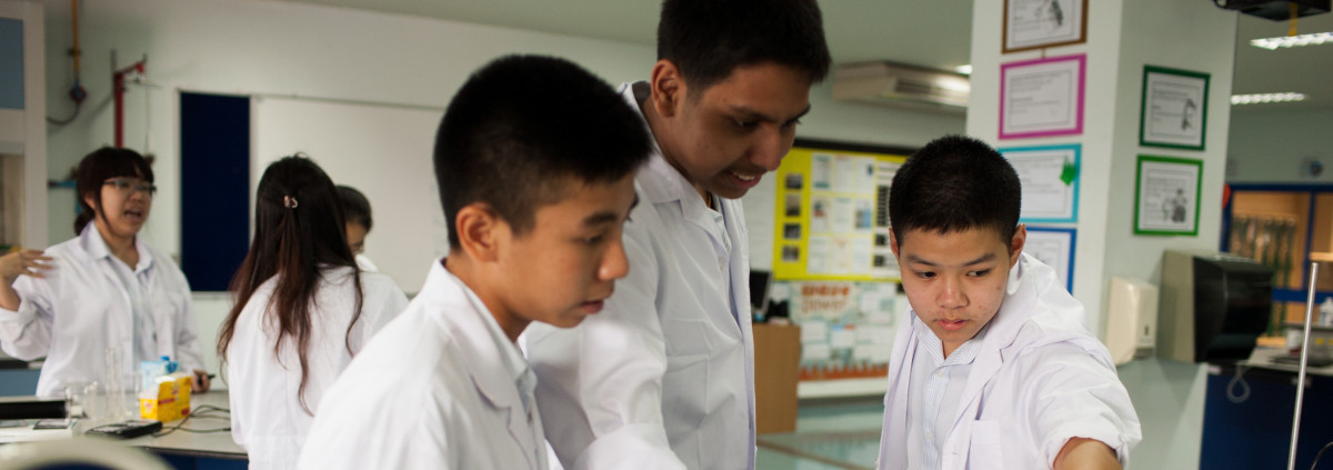 Students doing a laboratory experiment with the help of a teacher.
