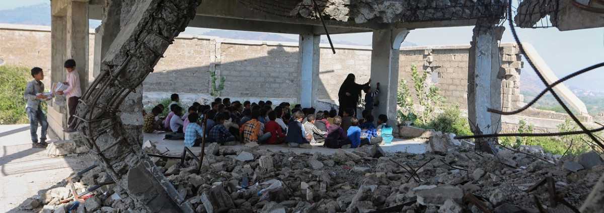 children in Yemen studying in a school destroyed by war