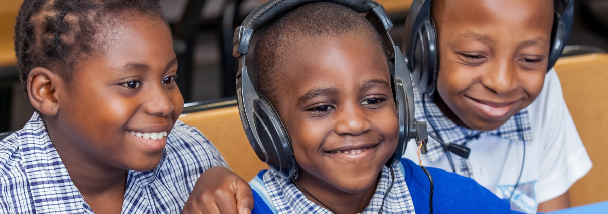 kids smiling while listening on headphones